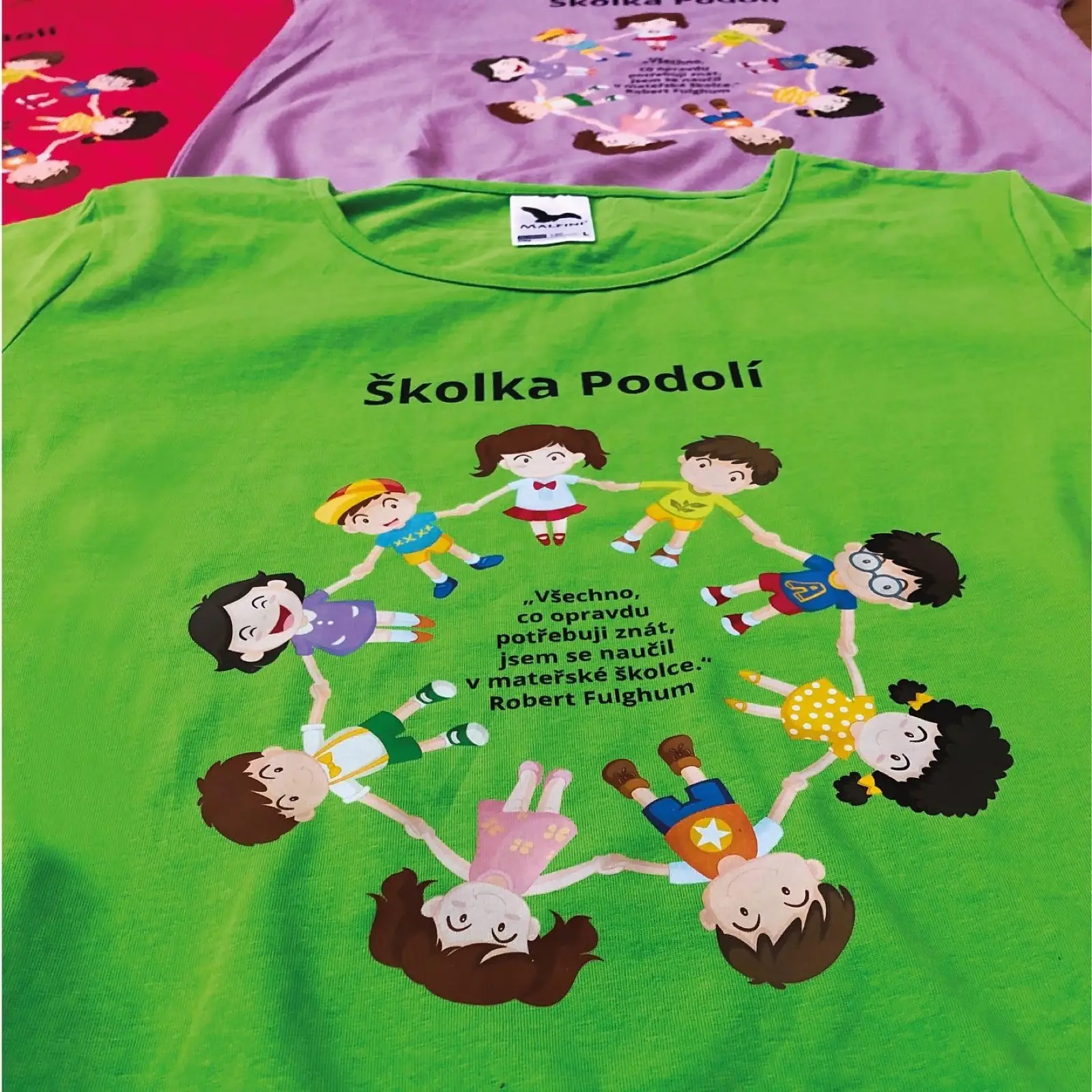 Zelené tričko s nápisem Školka Podolí a kresbou dětí v kruhu