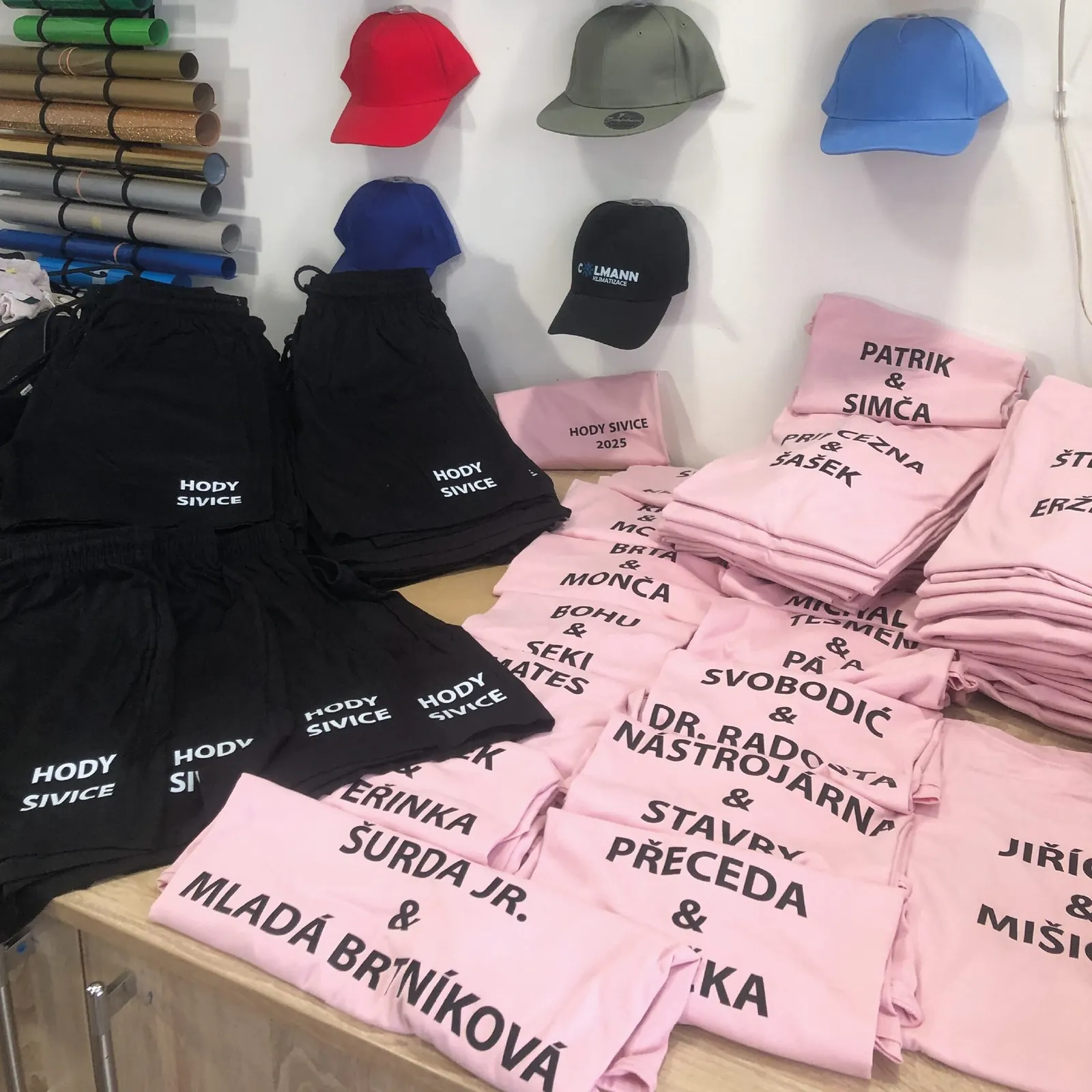Růžová trička se jmény a černé kšiltovky s nápisem Hody Sivice