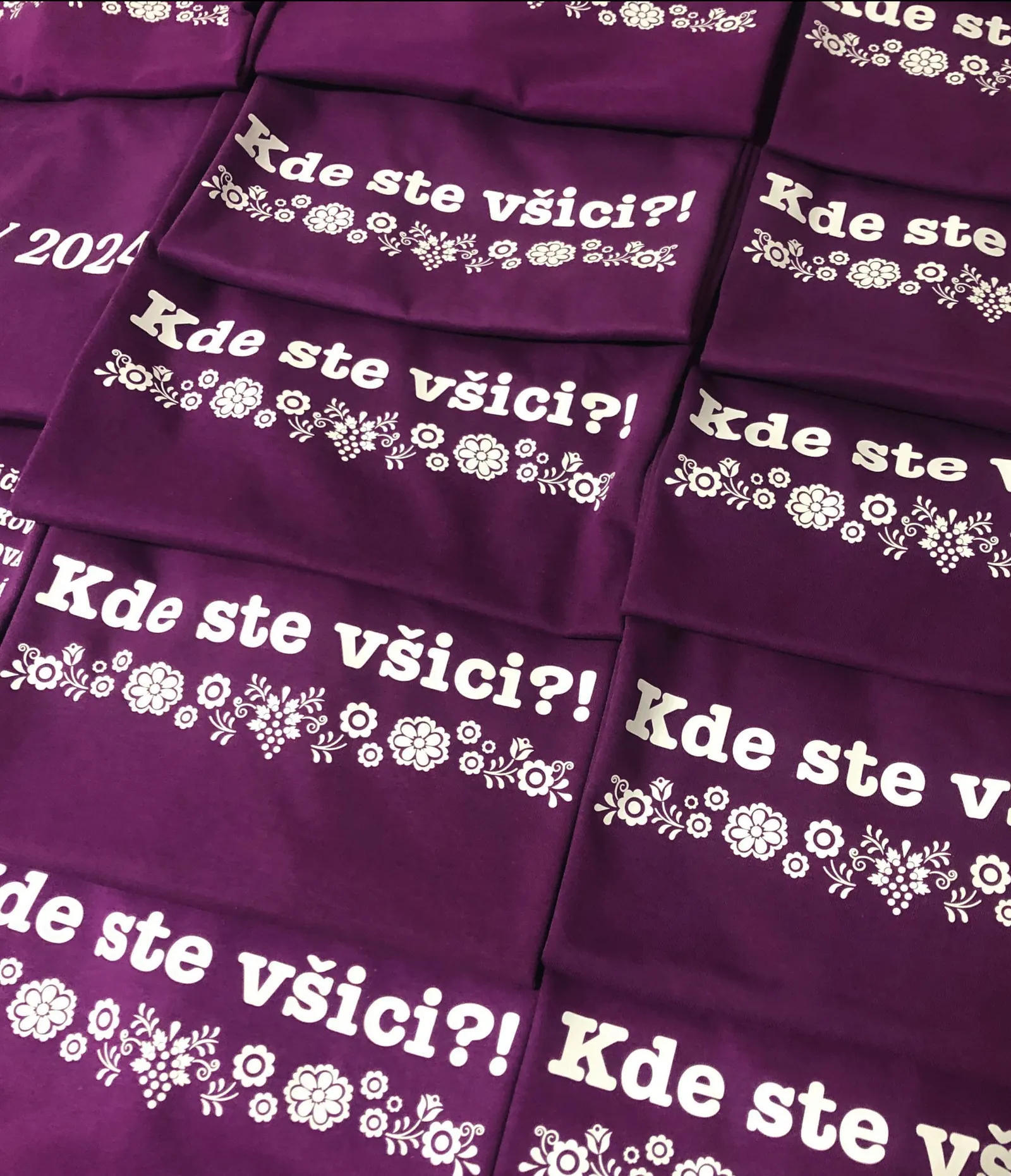 Fialová trička s bílým nápisem Kde ste všici?! a ornamentem